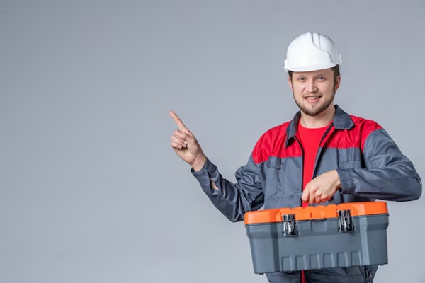 Front view of male electrician in uniform holding tool bag