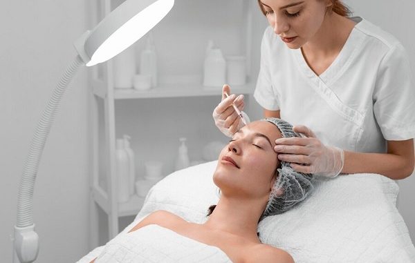 Beautician doing filler injection for client