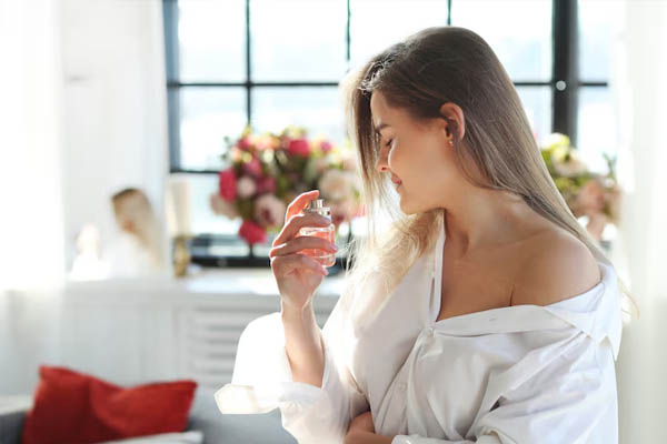 Young woman applying perfume