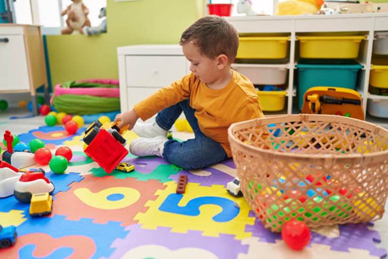 adorable-caucasian-boy-playing-tractor-toy-sitting-ground-kindergarten