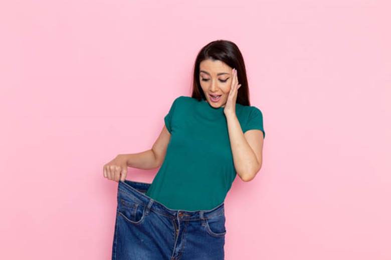 front-view-young-woman-green-t-shirt-checking-her-waist-pink-wall-waist-sport-exercise-workouts-beauty-slim-woman